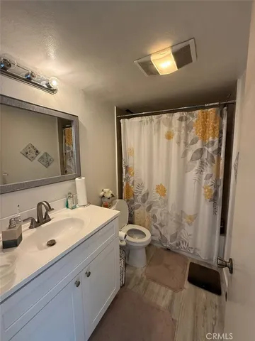 a bathroom with a sink mirror and a toilet