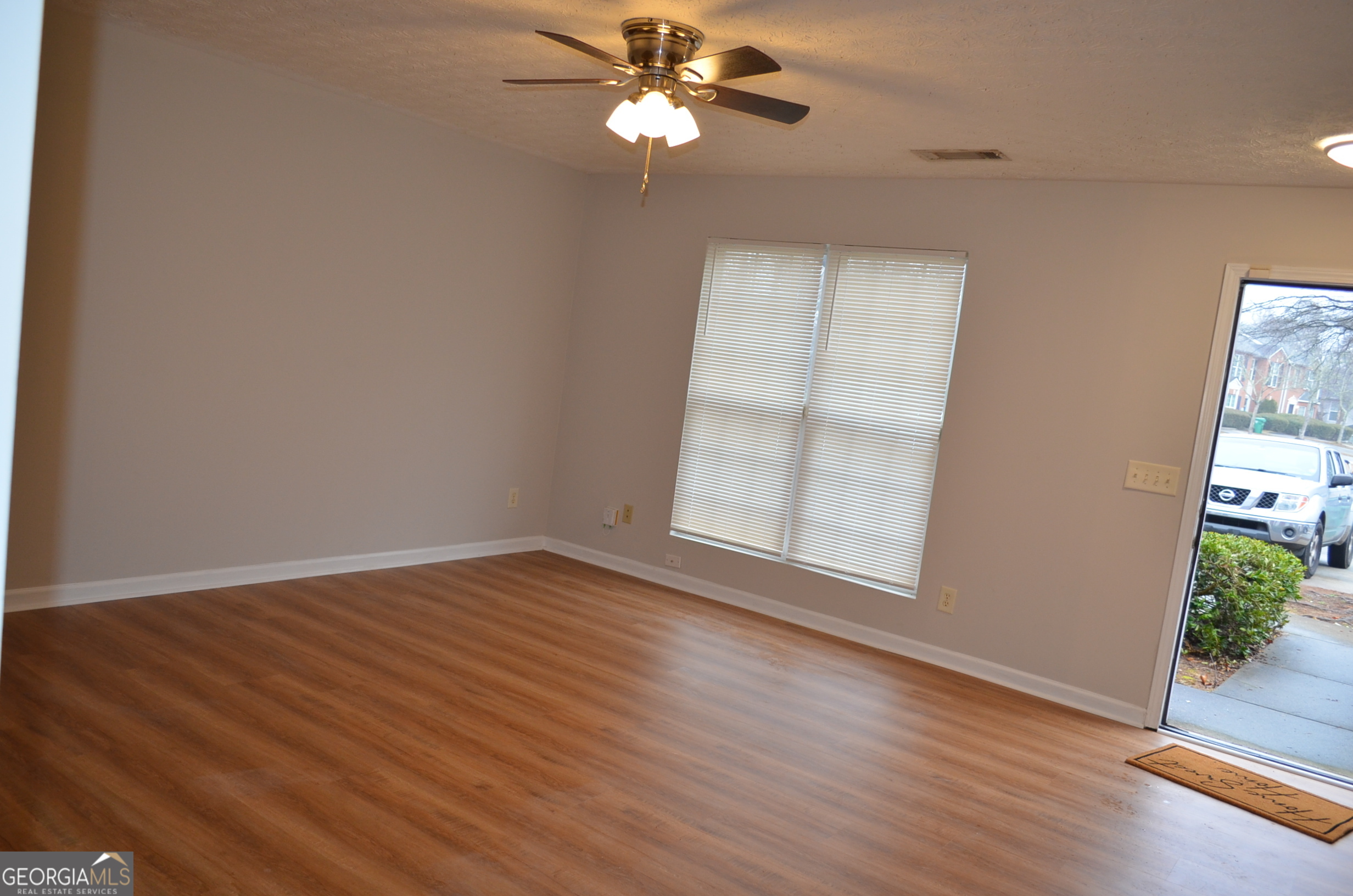 2722 Norfair Loop Lithonia, GA 30038 - Photo 6 of 25 an empty room with wooden floor chandelier fan and windows