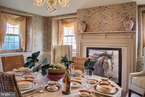 a dining room with furniture a chandelier and fireplace