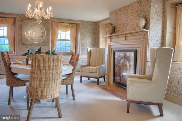 a living room with furniture a chandelier and a fireplace