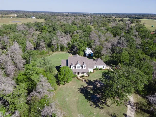 an aerial view of a house with a yard