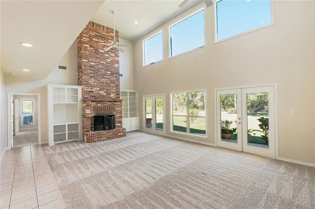 a view of an empty room with a fireplace and a window