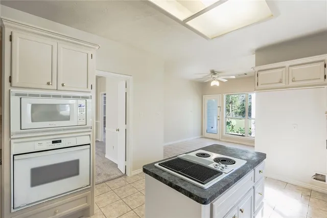 a kitchen with white cabinets and white appliances