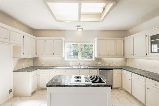 a kitchen with granite countertop a sink stove a microwave and cabinets