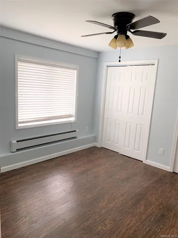 a view of an empty room with a window and a ceiling fan