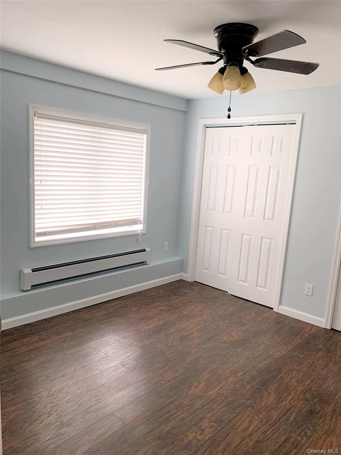 a view of an empty room with a window and a ceiling fan
