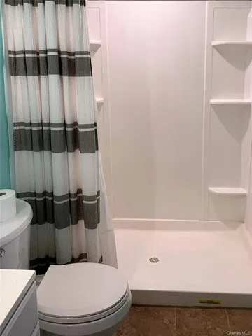 a bathroom with a toilet and a shower