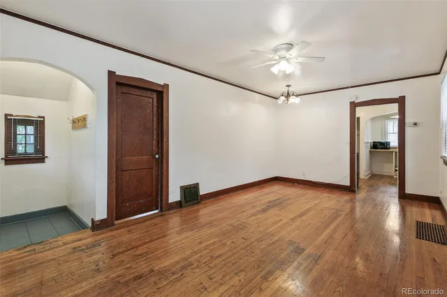 a view of a livingroom with wooden floor and a ceiling fan