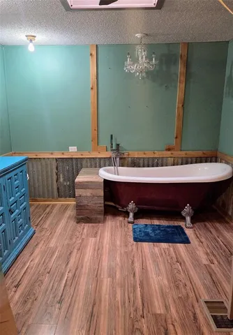 a room with a bed and a wooden floor