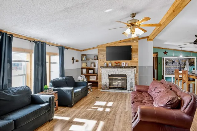 a living room with furniture a fireplace and a flat screen tv
