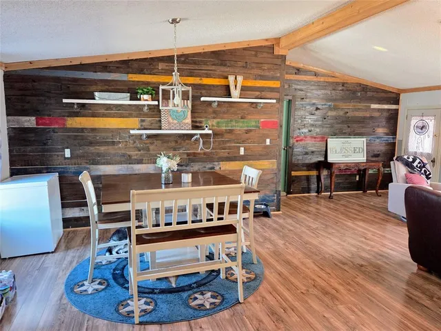 a living room with stainless steel appliances kitchen island granite countertop furniture and a wooden floor
