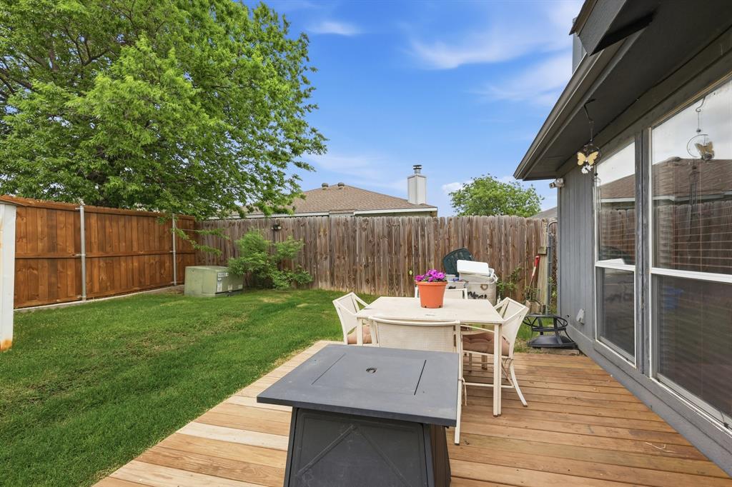 4217 Broken Arrow Road Fort Worth, TX 76137 - Photo 34 of 40 a view of a patio with a dining table and chairs with wooden floor and fence