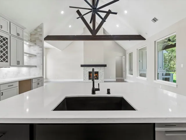 a bathroom with a sink double vanity granite tub and mirror