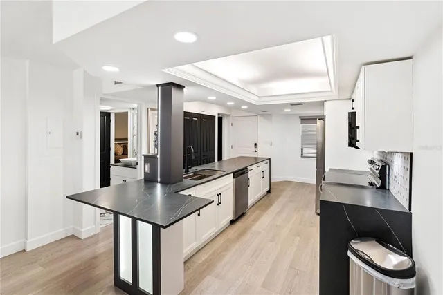 a kitchen with stainless steel appliances a microwave a stove and white cabinets