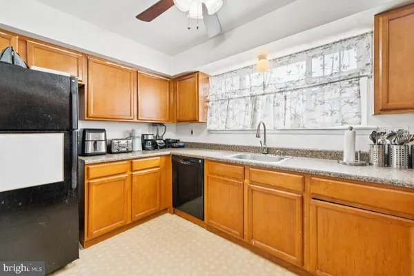 a kitchen with granite countertop stainless steel appliances a sink window and cabinets
