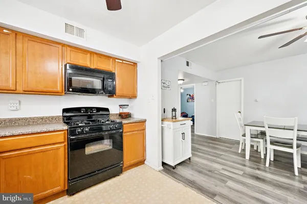 a kitchen with stainless steel appliances stove microwave refrigerator dining table and chairs