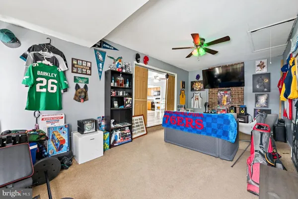 a living room with lots of baby toys and a flat screen tv