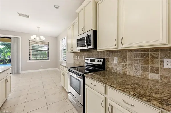a kitchen with stainless steel appliances granite countertop a sink and a stove