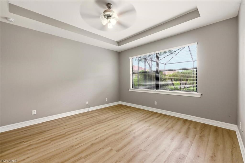 14513 Tuscany Pointe Trail Naples, FL 34120 - Photo 13 of 31 a view of an empty room with wooden floor and a window