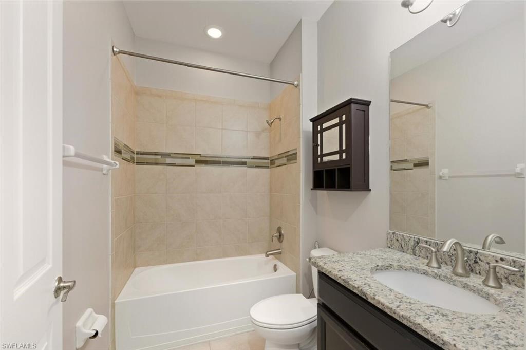 14513 Tuscany Pointe Trail Naples, FL 34120 - Photo 21 of 31 a bathroom with a granite countertop bathtub shower sink vanity and toilet
