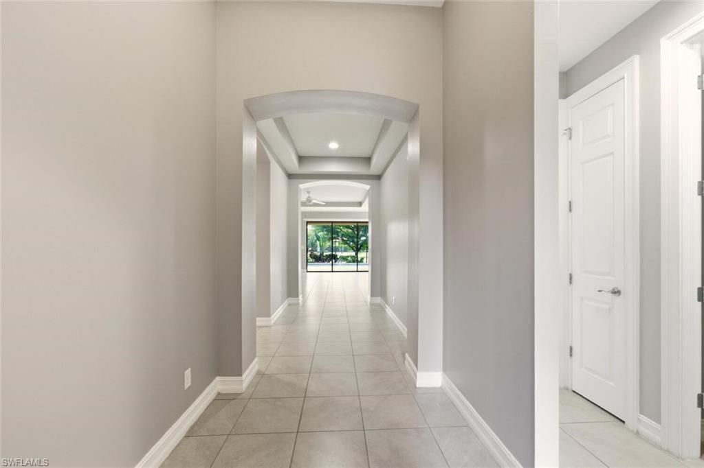 14513 Tuscany Pointe Trail Naples, FL 34120 - Photo 4 of 31 a view of a hallway with wooden floor and a bathroom