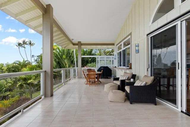 a living room with patio furniture and a floor to ceiling window