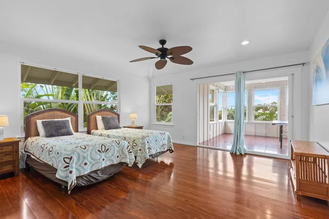 a bedroom with a bed a ceiling fan and a large window