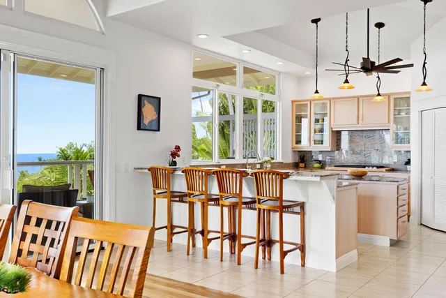 a kitchen with stainless steel appliances granite countertop a dining table chairs and granite counter tops