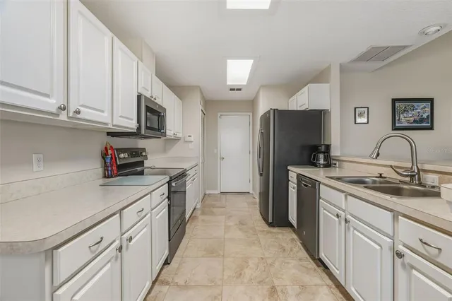a kitchen with cabinets stainless steel appliances and a sink