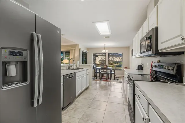 a kitchen with stainless steel appliances granite countertop a refrigerator and a stove top oven