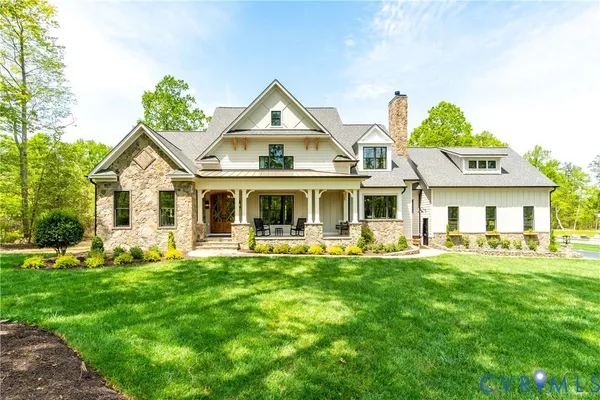 a front view of a house with a garden and trees