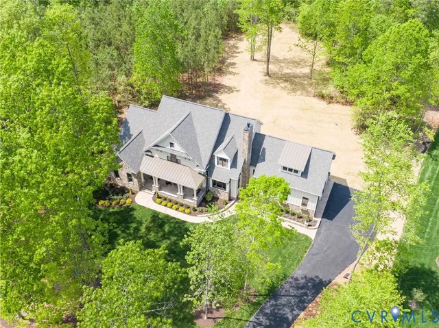 an aerial view of a house with a yard and trees