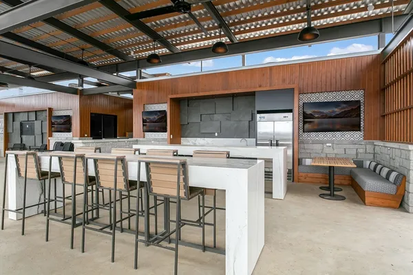 a kitchen with stainless steel appliances kitchen island granite countertop a table chairs sink and cabinets