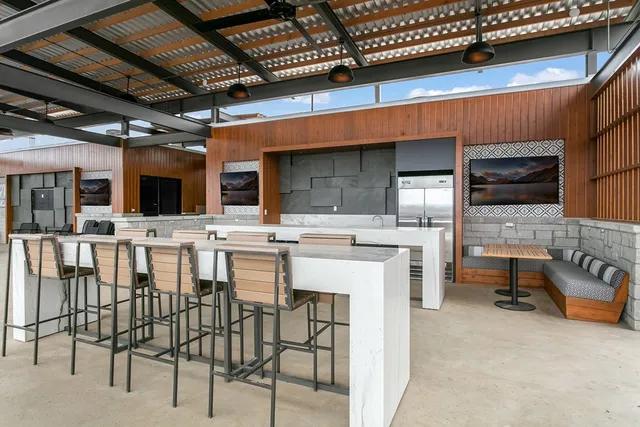 a kitchen with stainless steel appliances kitchen island granite countertop a table chairs sink and cabinets