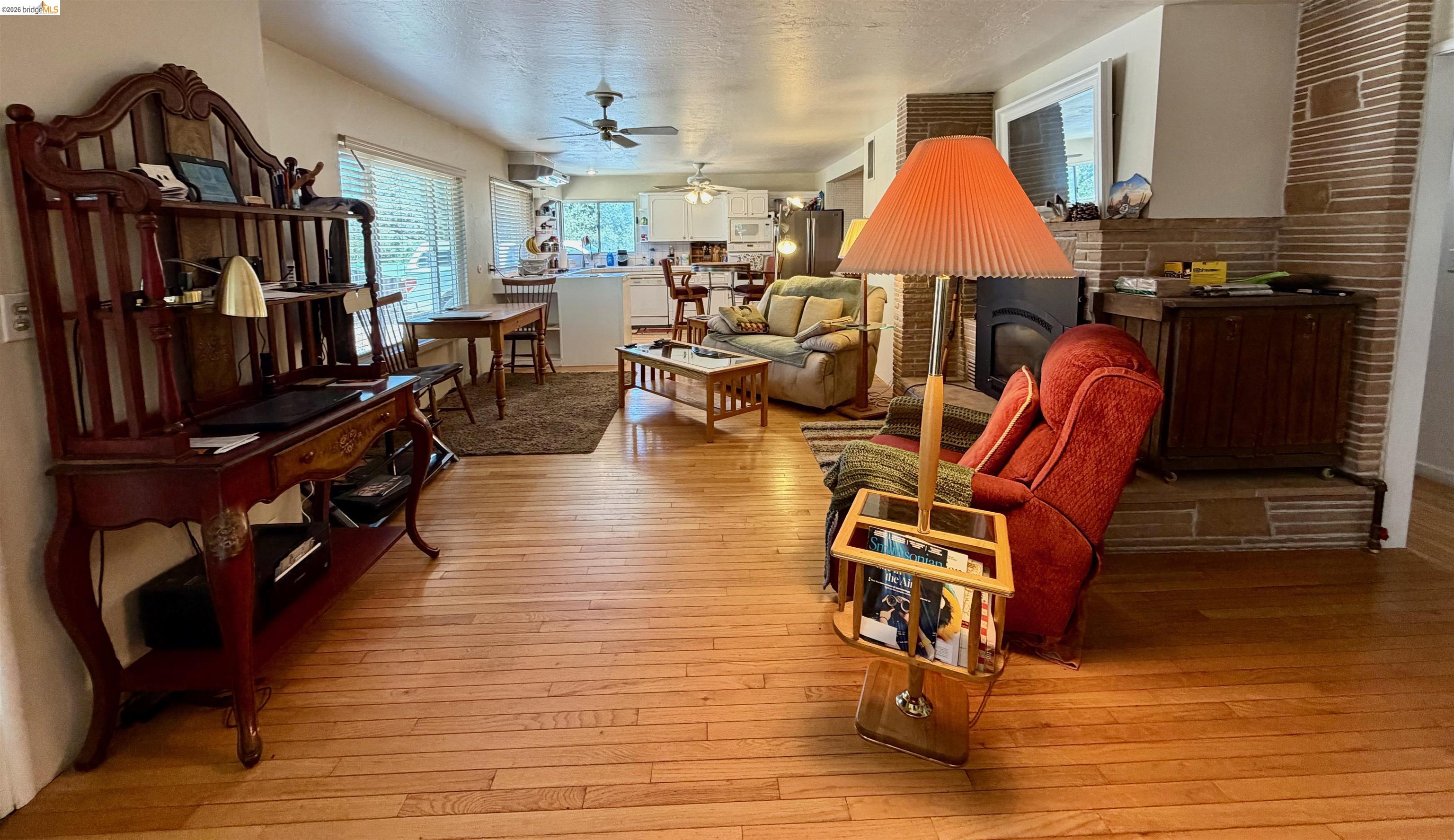 18195 Wards Ferry Road Sonora, CA 95370 - Photo 10 of 67 Expansive living space featuring wood-finish flooring throughout, a stone-clad fireplace, and multiple ceiling fans
