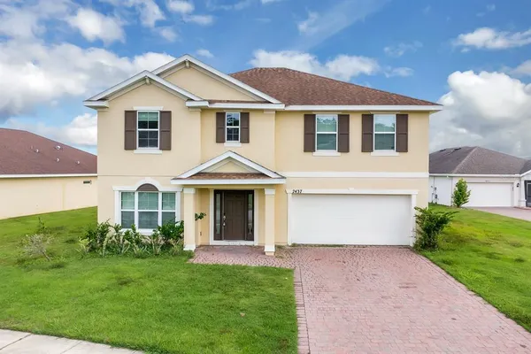 a front view of a house with a yard and garage