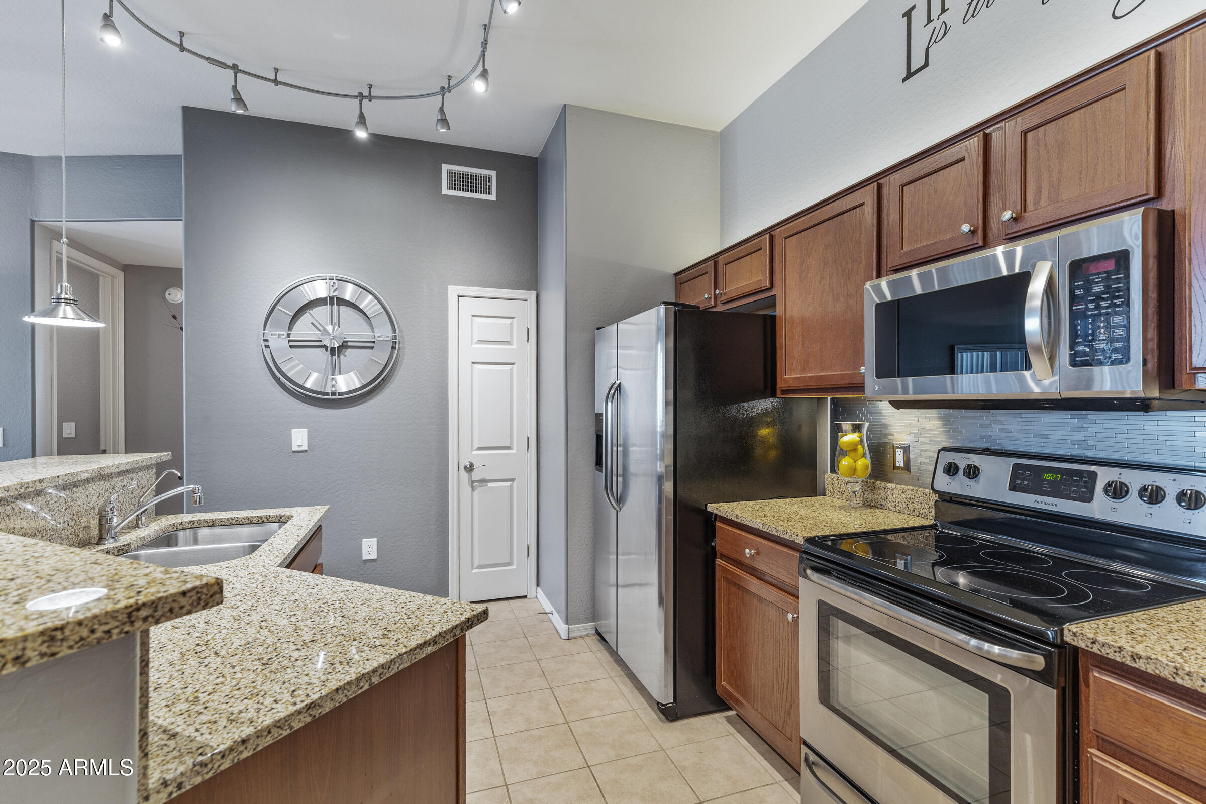 3330 South Gilbert Road, Unit 2013 Chandler, AZ 85286 - Photo 4 of 39 a kitchen with stainless steel appliances granite countertop a stove and a microwave