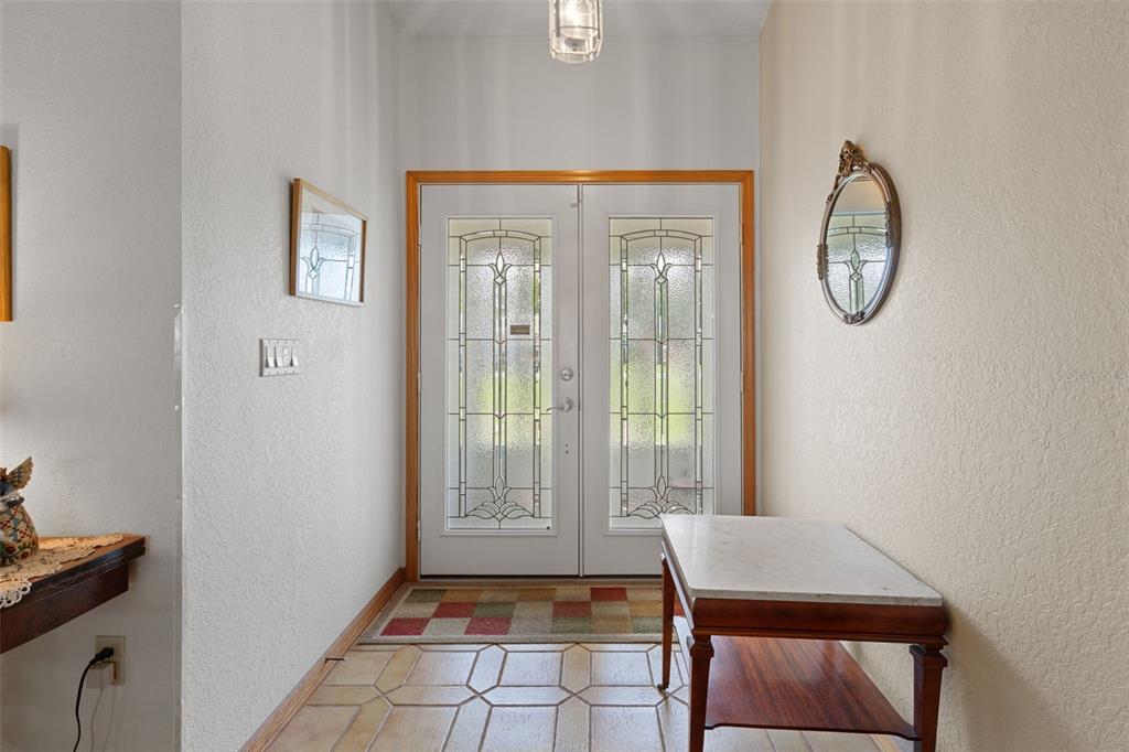 5035 Harbinger Road Spring Hill, FL 34608 - Photo 13 of 47 a view of a hallway with entryway wooden floor and front door