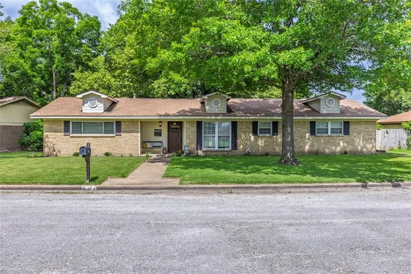a front view of a house with a yard and trees