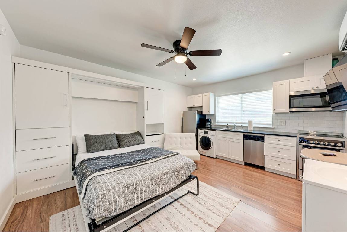 306 East 30th Street, Unit 102 Austin, TX 78705 - Photo 3 of 7 a bedroom with a large bed and a flat tv screen