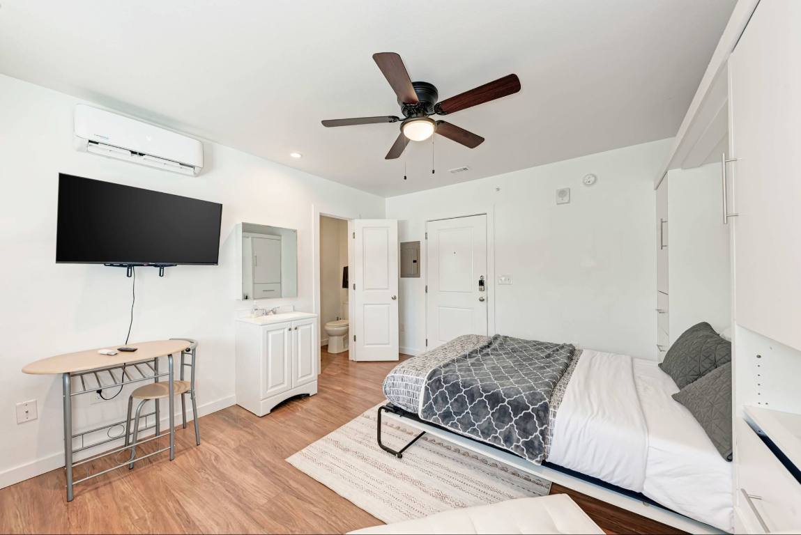 306 East 30th Street, Unit 102 Austin, TX 78705 - Photo 4 of 7 a living room with furniture and a flat screen tv