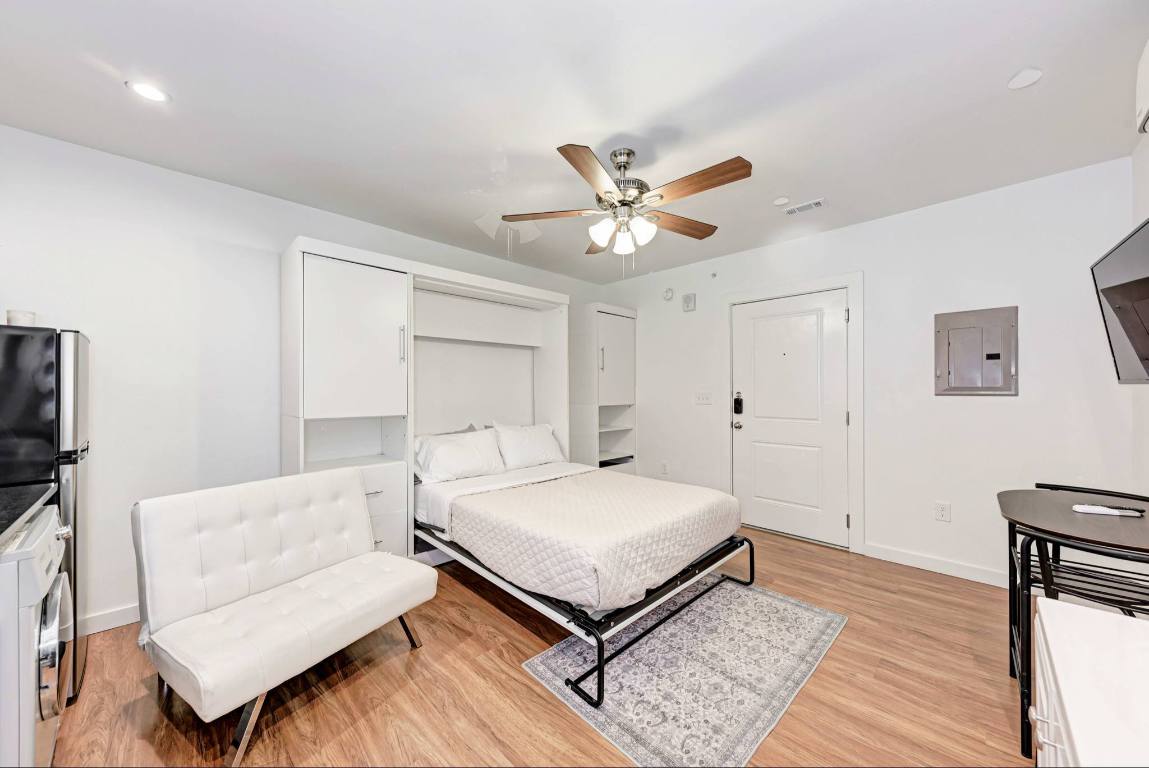 306 East 30th Street, Unit 102 Austin, TX 78705 - Photo 6 of 7 a bedroom with a bed and a couch