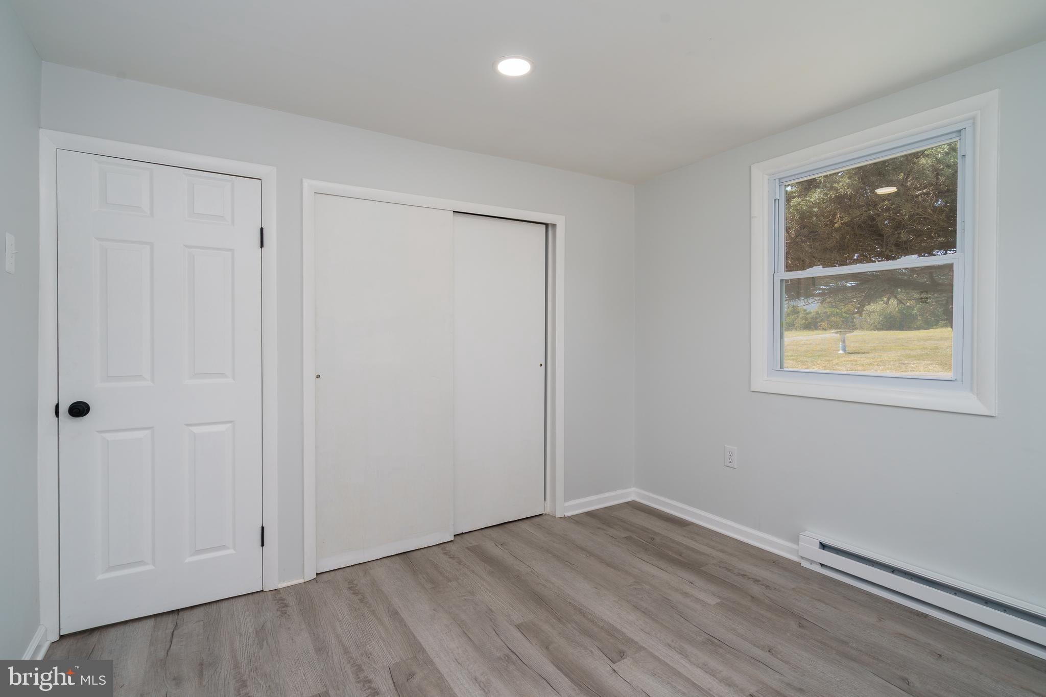 5781 Timber Ridge Road Berkeley Springs, WV 25411 - Photo 23 of 25 a view of an empty room with wooden floor and a window
