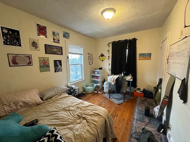 a bedroom with bed and wooden floor