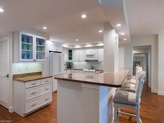 a kitchen with kitchen island granite countertop a stove and cabinets