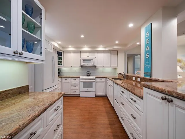 a large kitchen with stainless steel appliances kitchen island granite countertop a sink and cabinets