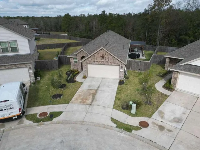 an aerial view of a house with a garden and parking space