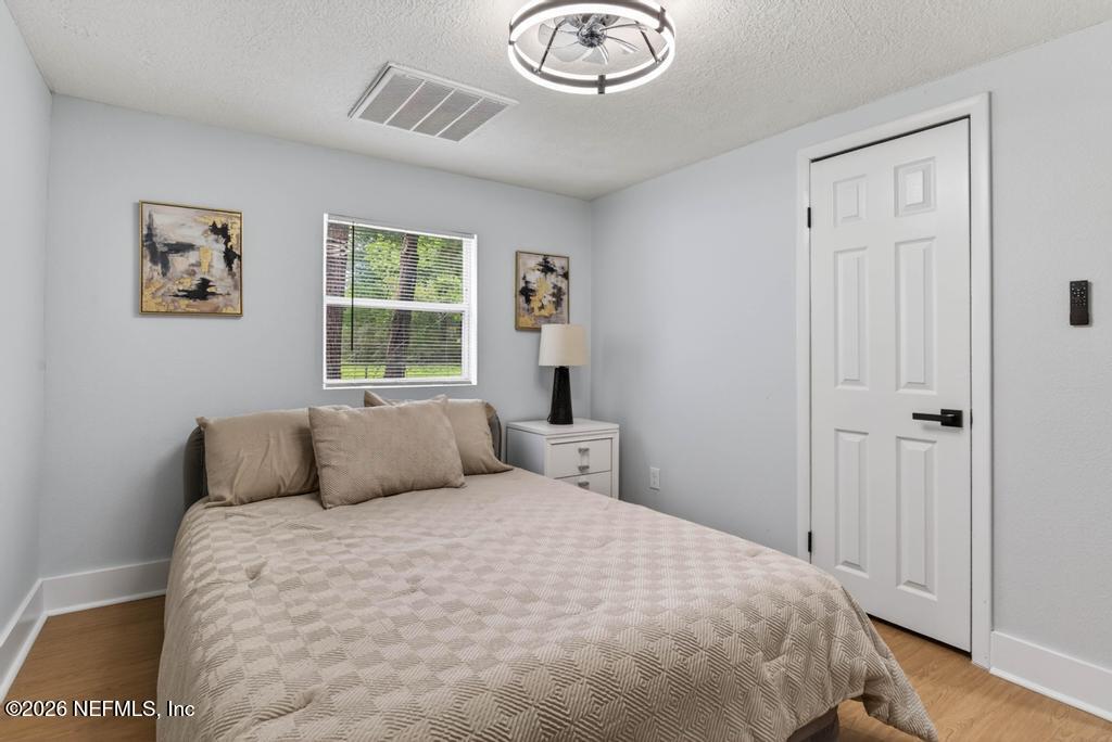 43739 Ratliff Road Callahan, FL 32011 - Photo 40 of 55 a bedroom with a large bed and a chandelier