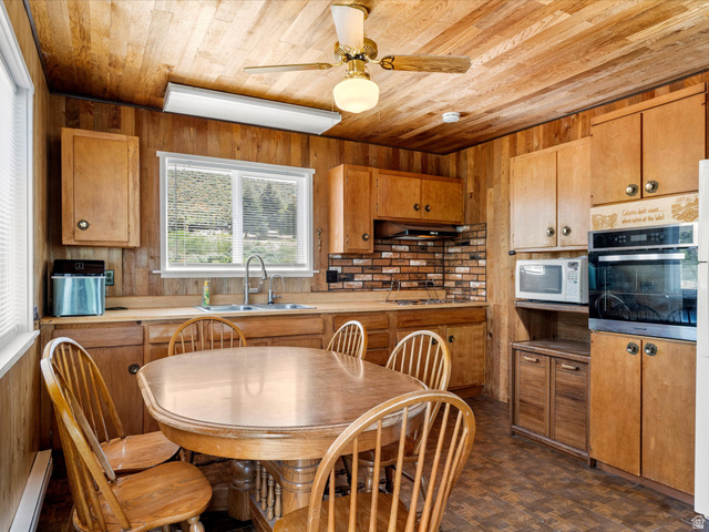 85 B Street, Unit 22 St. Charles, ID 83272 - Photo 18 of 35 Kitchen with wood walls and ceiling, featuring wood-finish cabinetry, a built-in oven, and a double basin sink