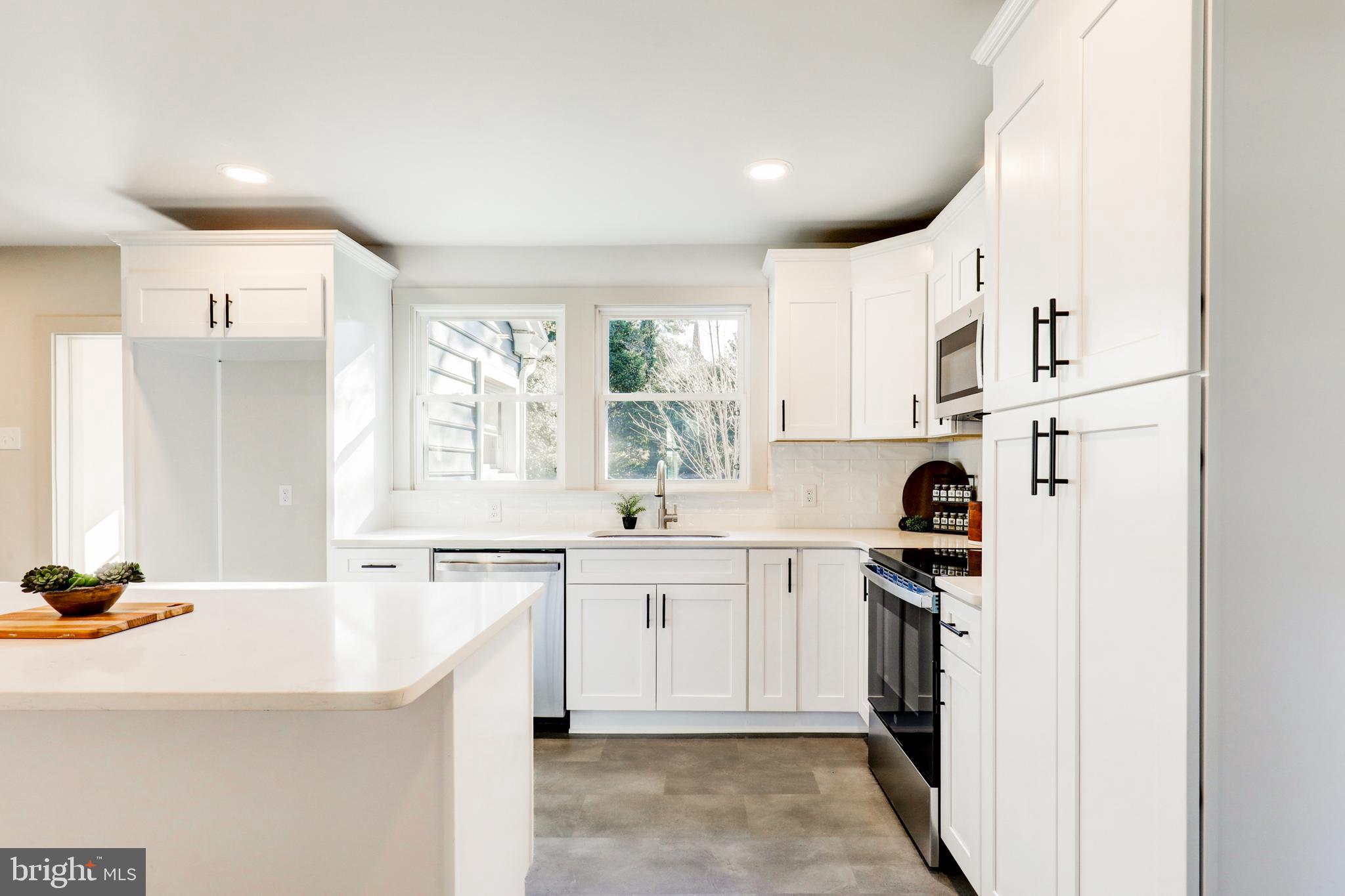 1081 Wynnwood Road Abington, PA 19001 - Photo 11 of 45 a kitchen with a sink a stove a refrigerator and white cabinets